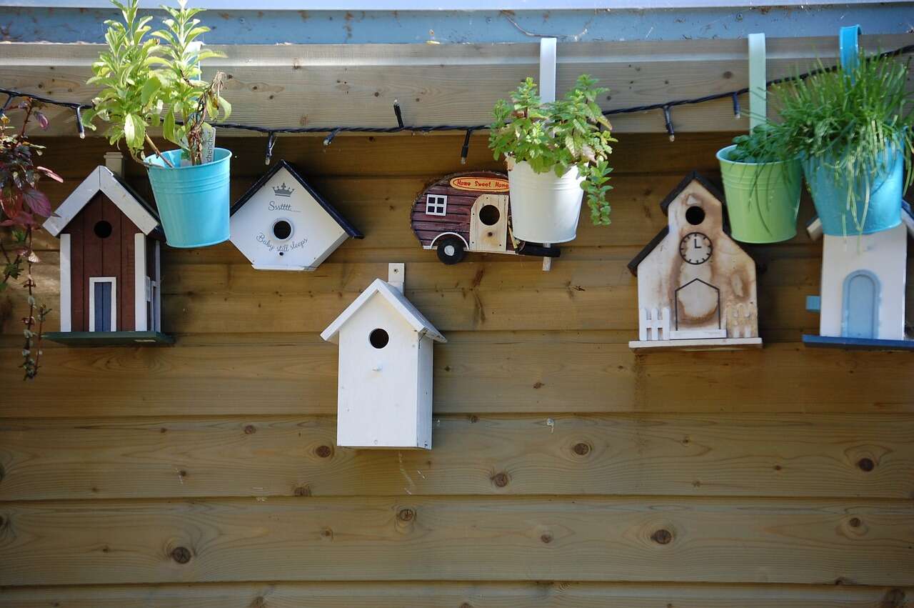 Wooden Garden building with bird houses and flower pots hanging from walls