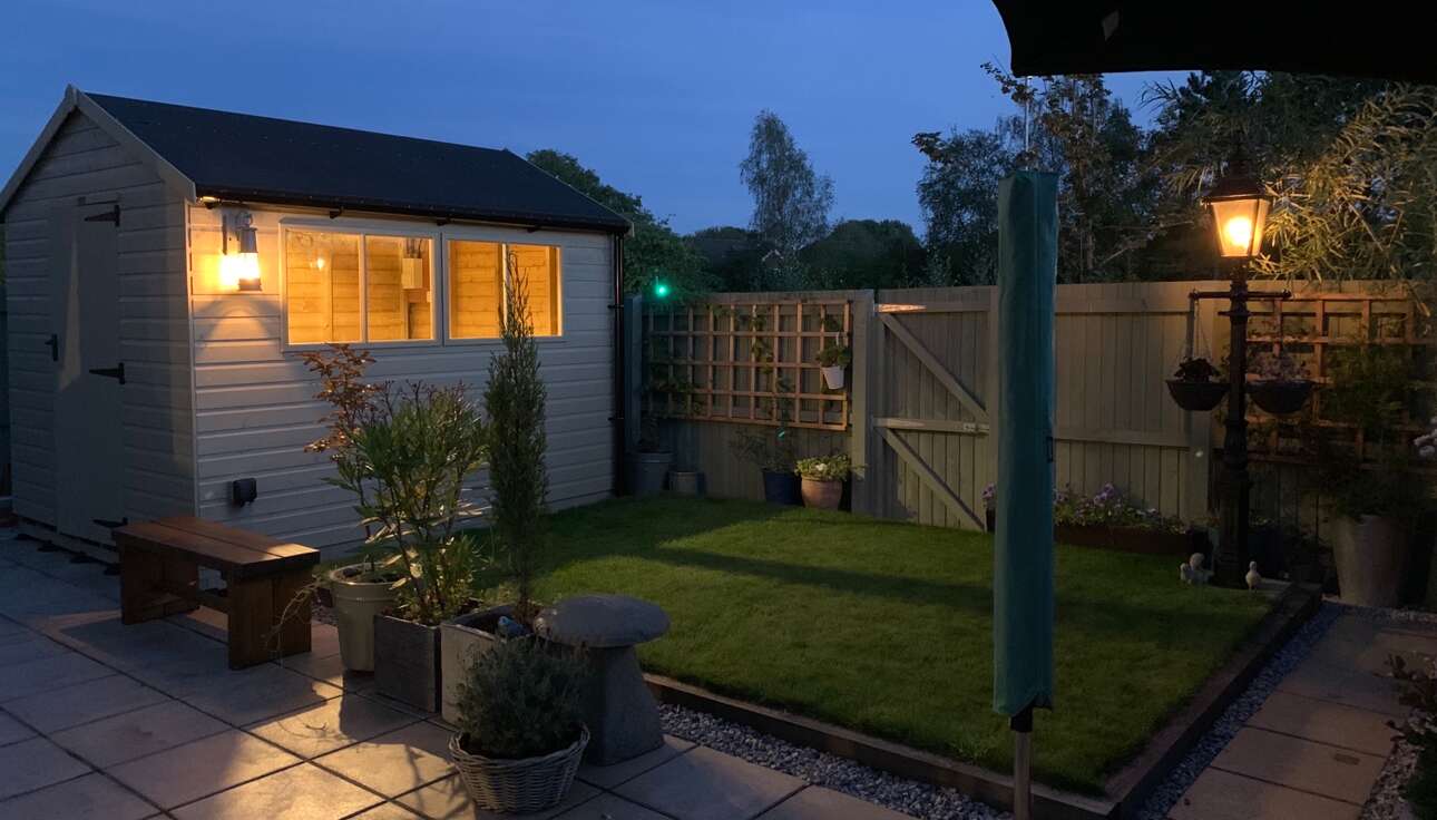 10x8 Tiger Elite Pressure-Treated Apex Shed in garden with outside light