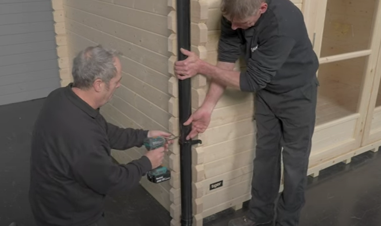 A picture of two men installing shed guttering