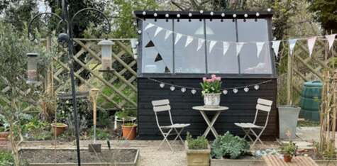 Tiger Potting Shed Exterior with Windows in Garden setting with bunting and table and chairs