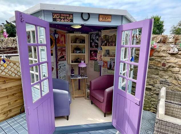 Tiger Corner Summerhouse painted in purple in garden with comfy seating