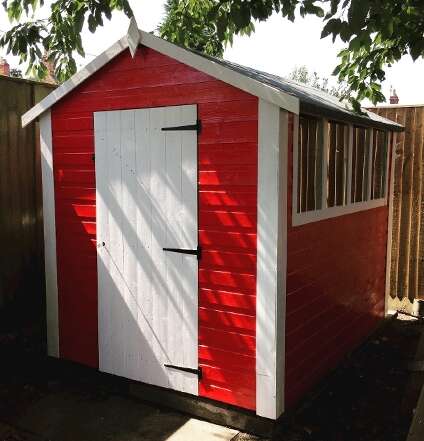 TigerFlex Shiplap Apex Shed painted in red and white in garden