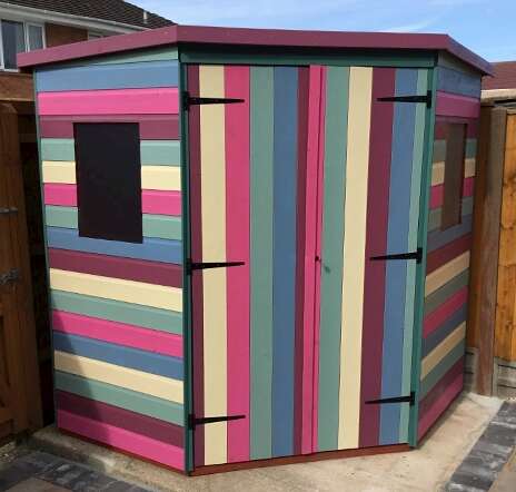 Colourful Painted Tiger Corner Shed painted in pink, cream, green, blue and purple