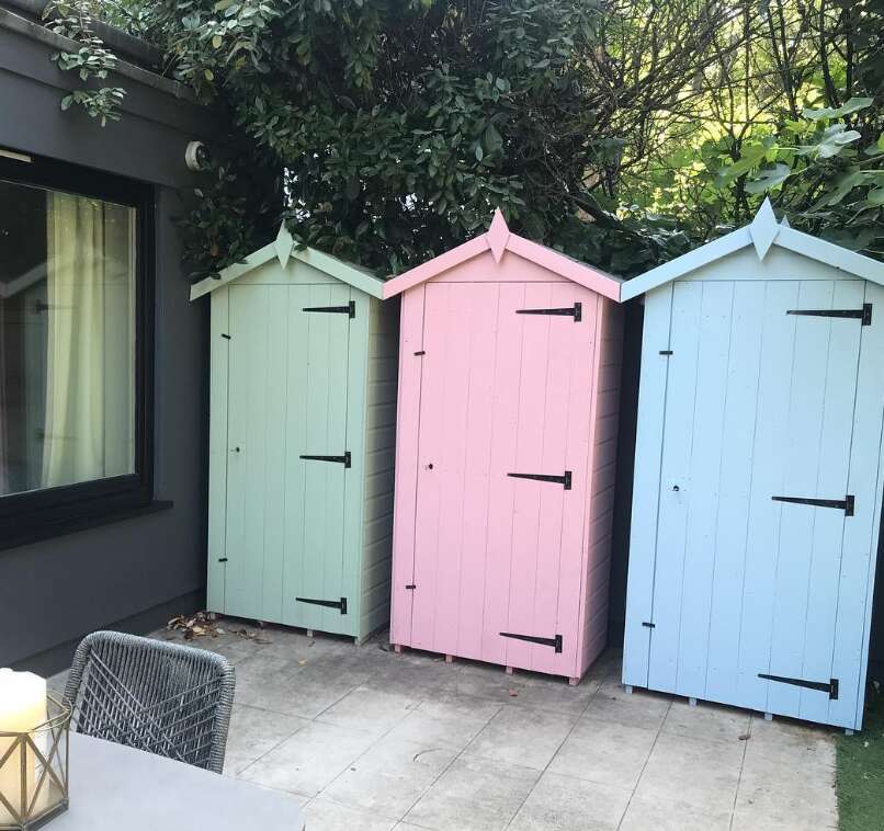 Tiger Tool Shed painted in pastel colours in garden with patio and grass