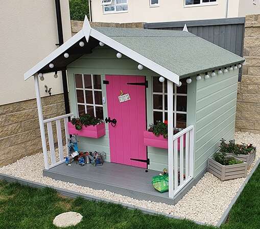 Tiger Tigercub Funhouse wooden playhouse painted in grey with pink door and pink window boxes