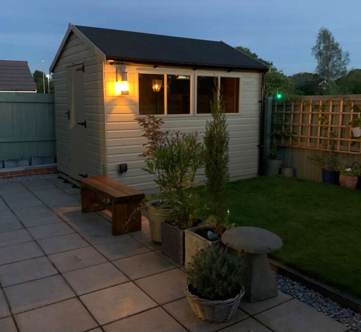 10x8 Tiger Elite Pressure-Treated Apex Shed in garden with grass and patio