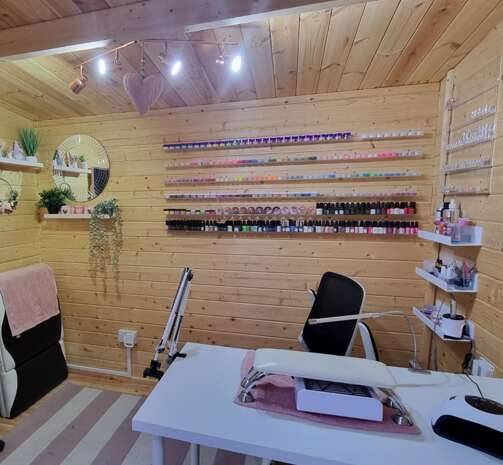 Tiger Blake Log Cabin interior, beauty salon, nail bar, table and chair, shelving