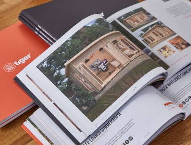Tiger Sheds and Tiger Log Cabins brochures, open pages with pictures of log cabins and text