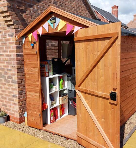 A picture of a Tiger Shiplap Apex Shed with door open, storage inside with storage cubes 