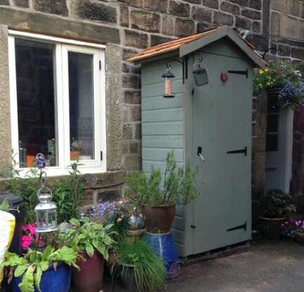 A picture containing a Tiger Wooden Tool Tower painted in soft green in garden with flower pots and garden lantern