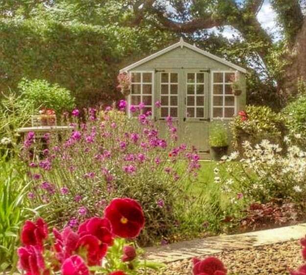 A picture containing outdoor, tree, flower, plants, wooden summerhouse