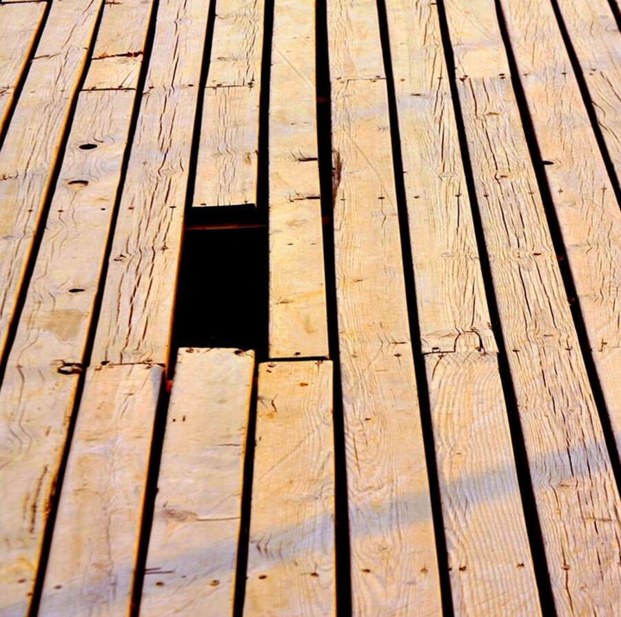 A picture containing a broken wooden deck, decking, timber decking