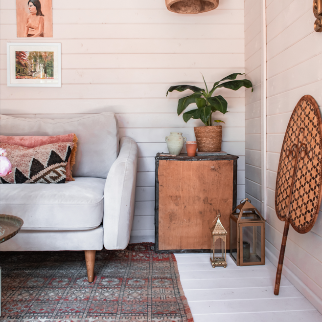 A tiger sheds persian log cabin interior, boho style, sofa, rug, table, plants