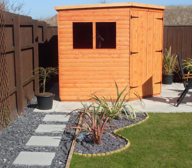 A picture containing a wooden corner shed, garden, grass, patio