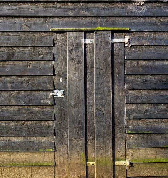 A picture containing an old shed door