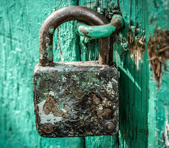 A picture containing a rusty shed lock