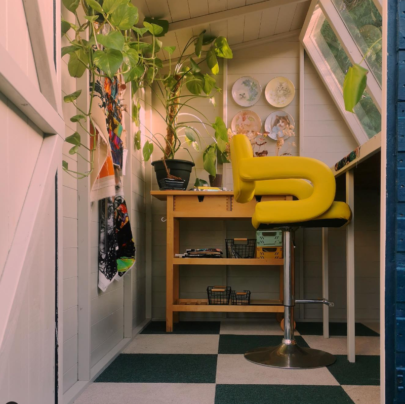 A potting shed being used as an art studio, creative space with chair and desk