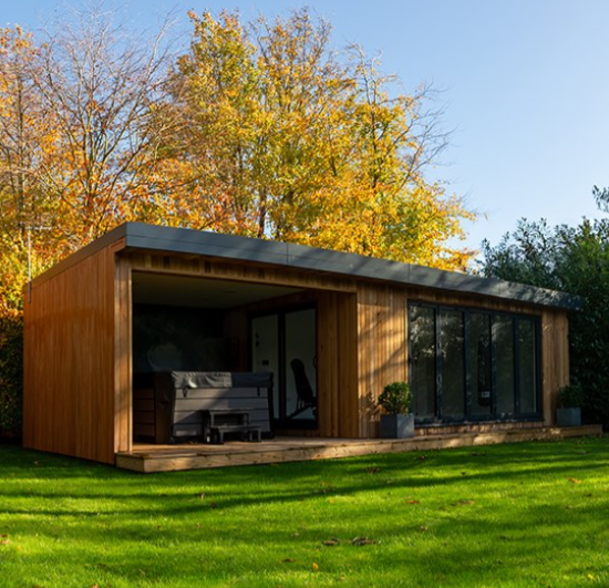 An insulated garden building with a porch and a lawn