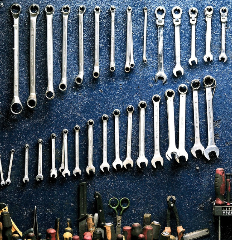 A picture containing a tool rack, tools hanging from wall