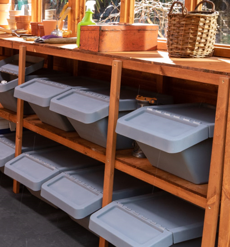 A picture containing a shed with wooden, shelves, tool bench, plastic storage boxes