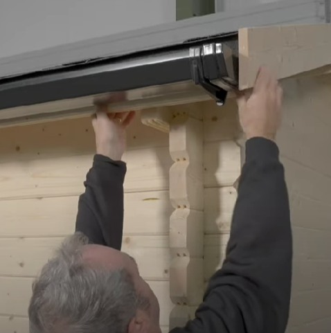 A picture of man installing shed guttering