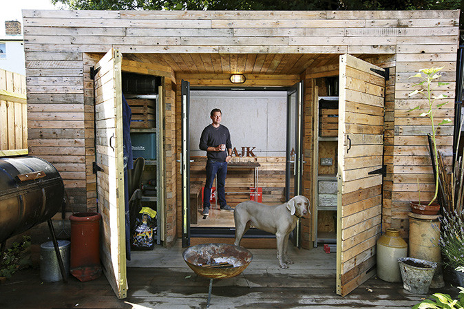 Man standing in shed with his dog
